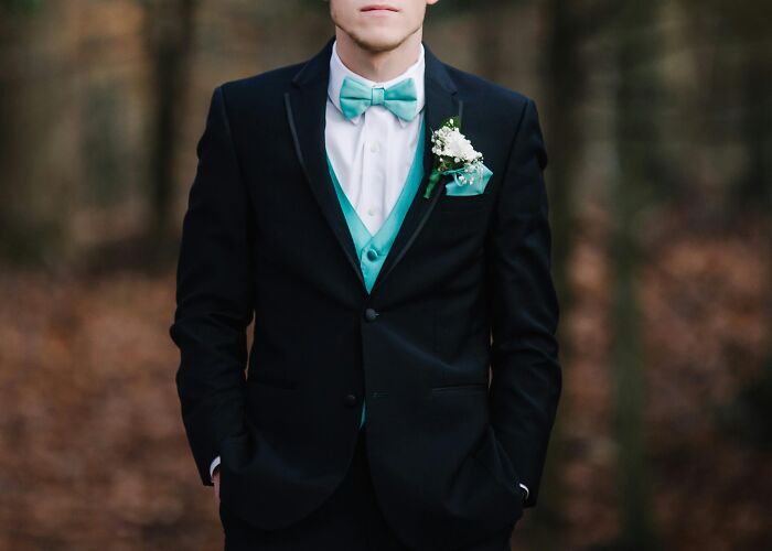 Man in a black suit with a turquoise bow tie and vest, featured in mic-drop-moments theme.