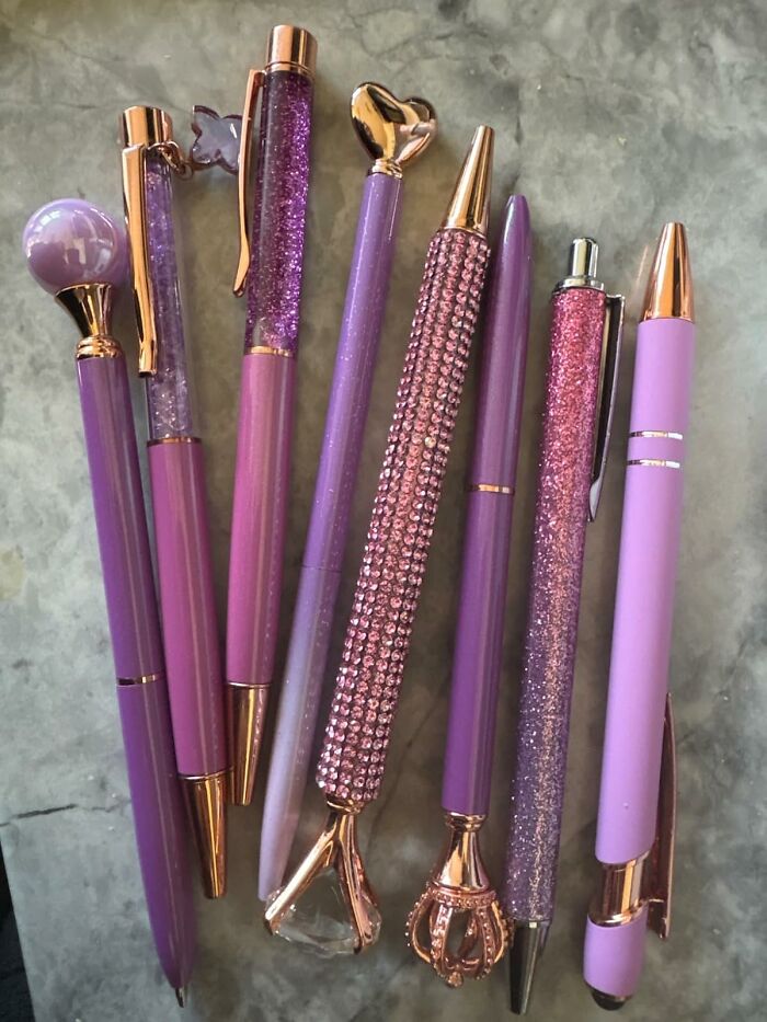 Purple and rose gold pens with sparkling designs, perfect Galentine's Day gifts.