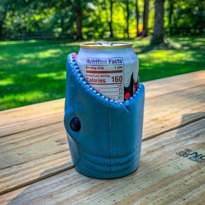 Shark-themed can cooler on a picnic table, ideal as a hilarious Valentine's Day gift.