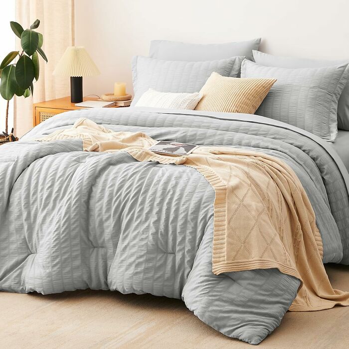 Cozy bed with soft bedding and throw blanket, a worthwhile investment for comfort.