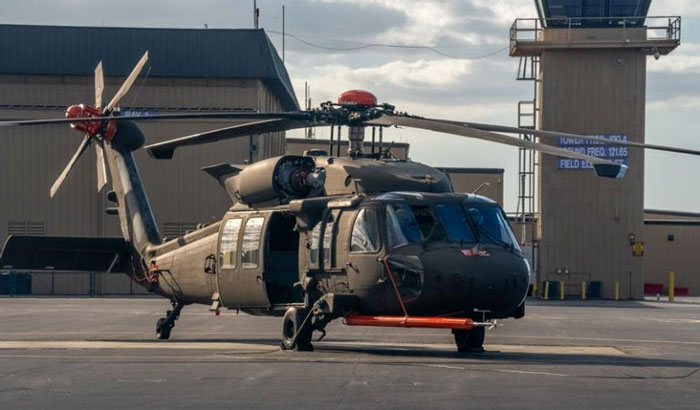 Black Hawk helicopter on tarmac at airfield before DC plane crash with visible control tower in background.