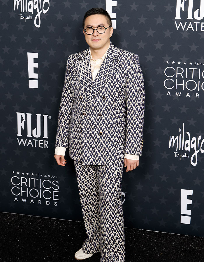 Person in a patterned suit at the Critics Choice Awards red carpet, posing for photos.