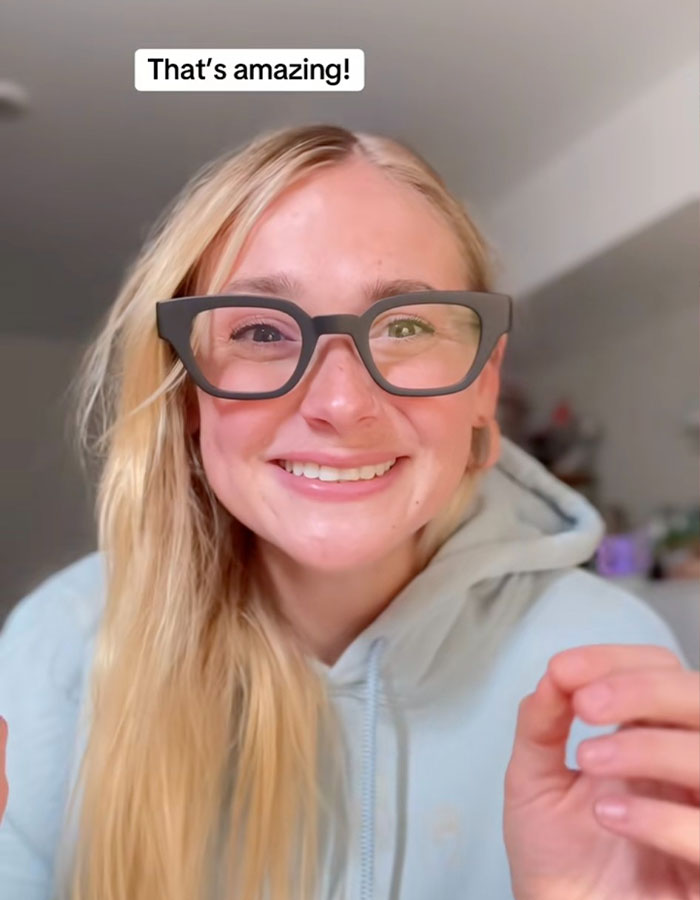 Deaf girl smiling, wearing augmented reality glasses, experiencing spoken words visually for the first time.