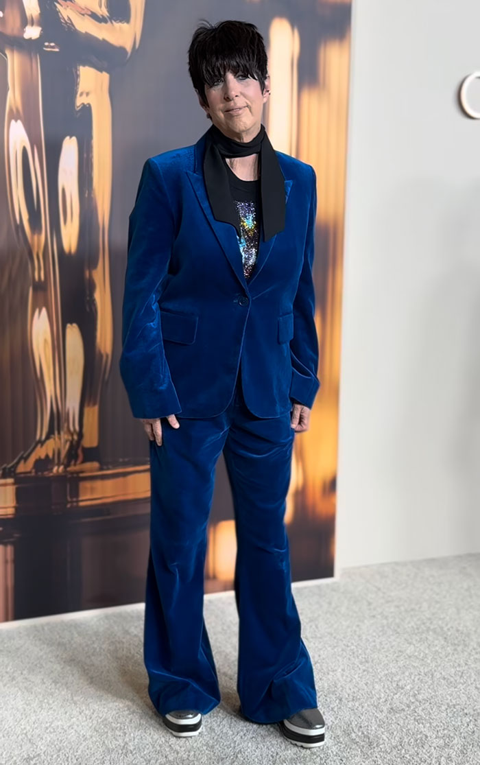 Person in a blue velvet suit at the 2025 Oscar Nominees Dinner, showcasing fashion triumph.