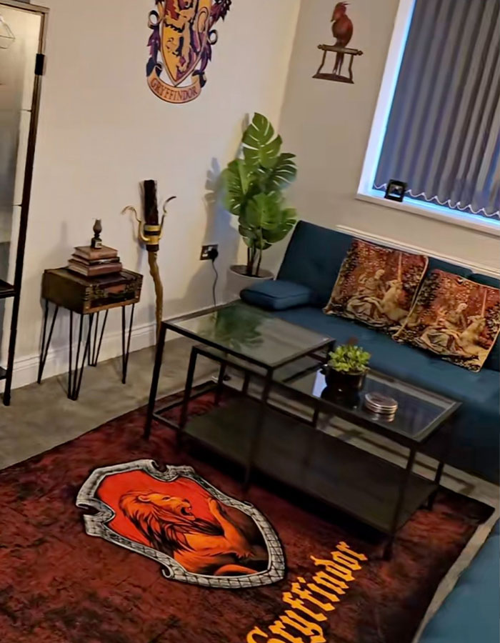 Harry Potter-themed Airbnb living room with Gryffindor decor, including a rug, wall art, and cushions.