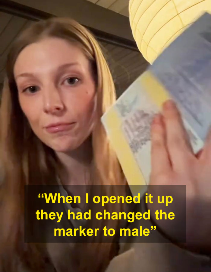 Trans actress holding passport with male marker mistake, highlighting gender identity error.