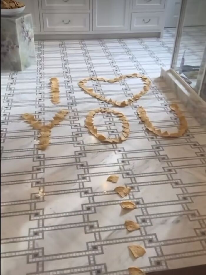 Potato chips arranged on a tiled floor to spell "I love you".