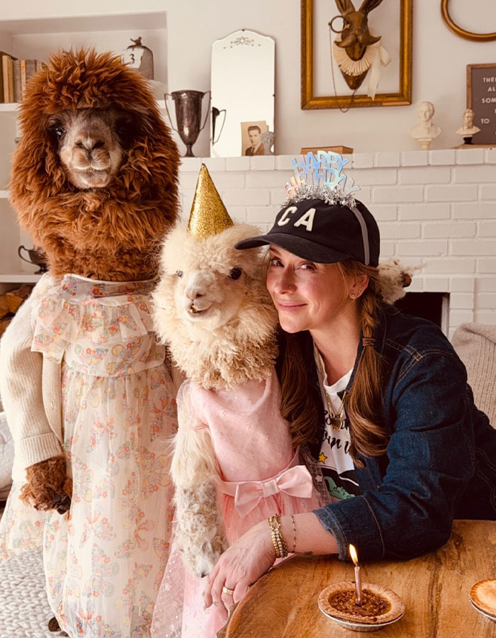 Woman celebrating birthday with alpacas, highlighting embracing aging.