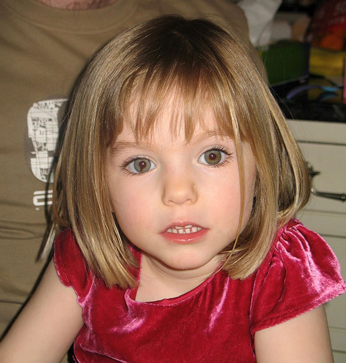 Young girl with brown hair in pink dress, associated with Madeleine McCann case.