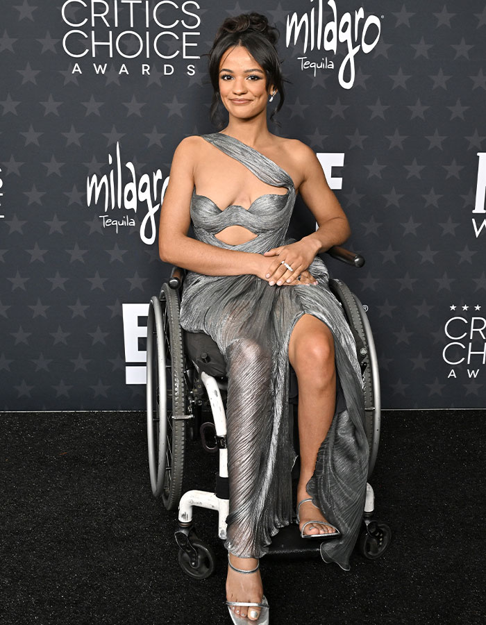 Person in a daring silver dress at the Critics Choice Awards red carpet.