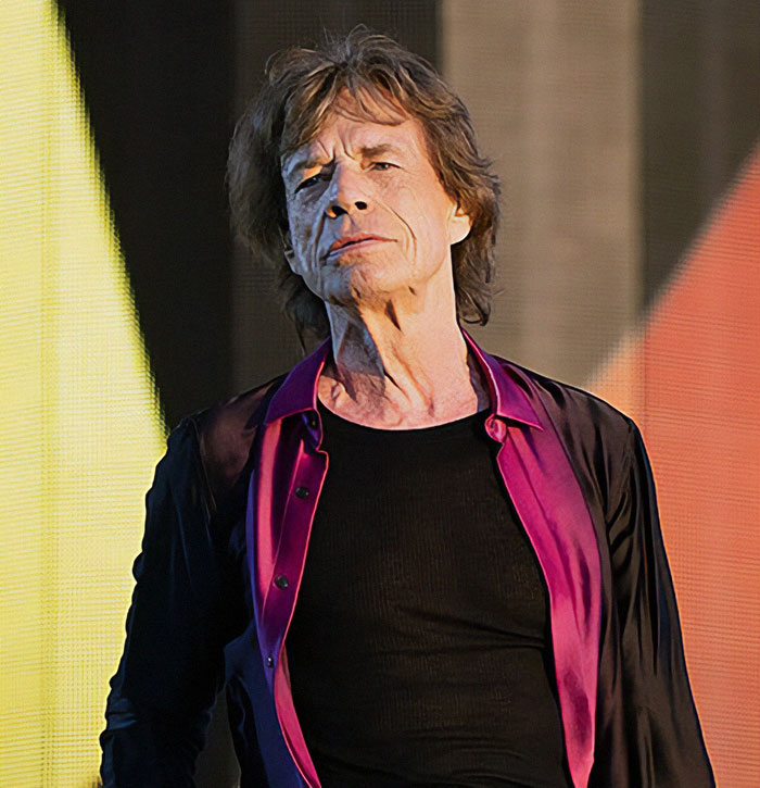 A person performing on stage, wearing a black shirt and purple open shirt, related to secret celebrity documents.