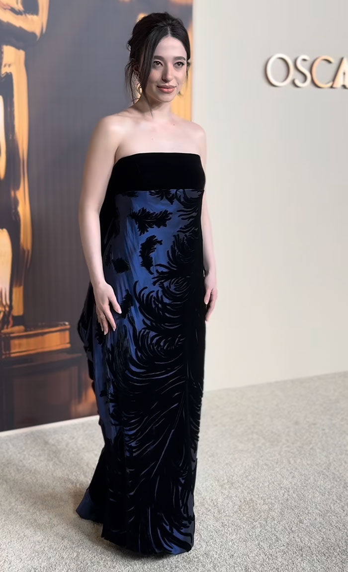 Woman in an elegant strapless gown at the 2025 Oscar Nominees Dinner.