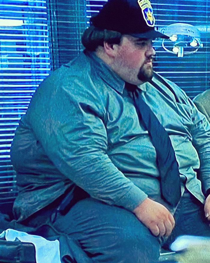 Man in uniform, sitting indoors, reflecting on Ozempic journey and 300-lb weight loss.