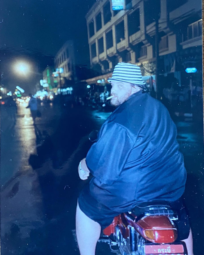 Man on motorcycle at night, reflecting on weight loss journey.