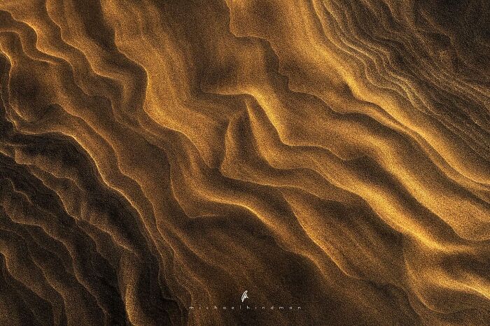 Close-up of sand dunes with flowing patterns, showcasing the textures of nature.