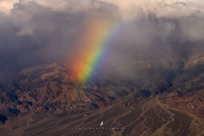 Rainbow over rugged mountains, showcasing textures of nature in an intimate landscape photo by Michael Hindman.