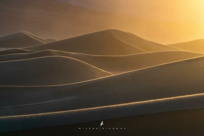 Golden light on sand dunes capturing the textures of nature in an intimate landscape photo by Michael Hindman.