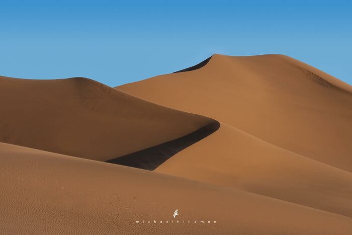 Intimate landscape photo of desert sand dunes under a clear blue sky by Michael Hindman.