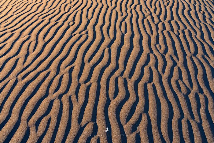 Textured sand patterns in an intimate landscape photo, evoking the natural beauty of nature's textures.