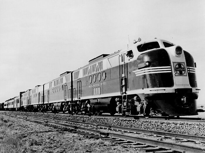 Black and white photo of a Santa Fe train on tracks, highlighting a random fact about the world.