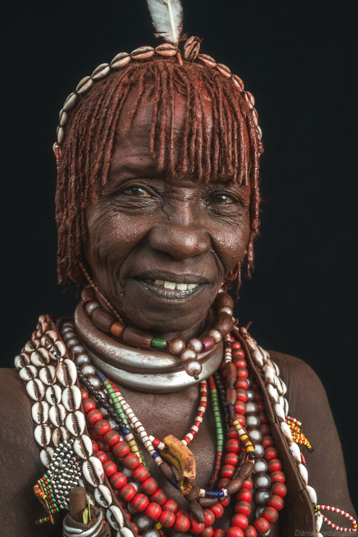 Ethiopian person adorned in traditional jewelry and hair decorations, captured in Daniel Kordan's photography.