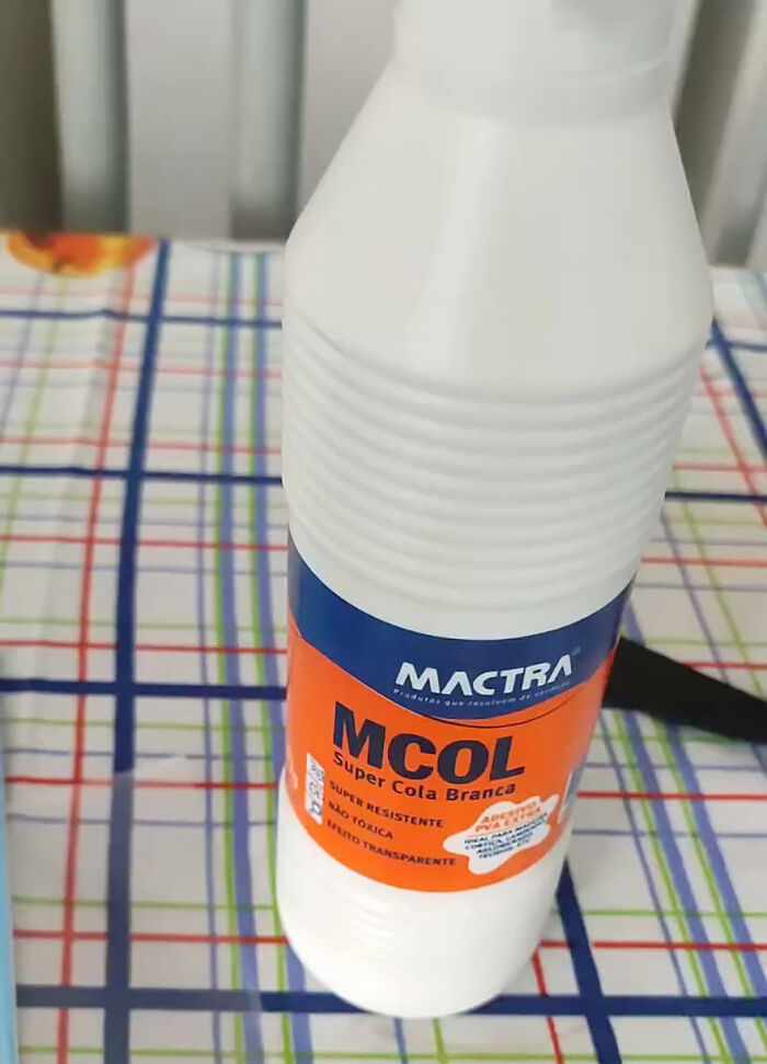 Bottle of glue on a checkered table, part of a funny prank played by a guy on his family.