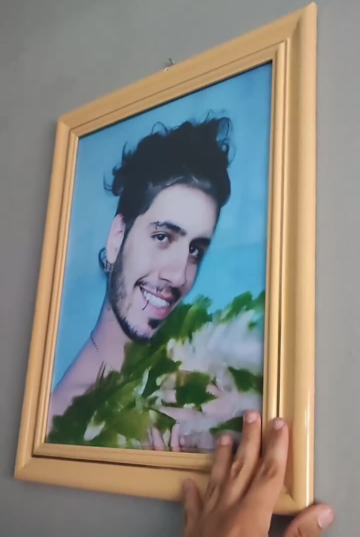 A framed photo of a smiling man holding greens, part of a funny prank on his family.