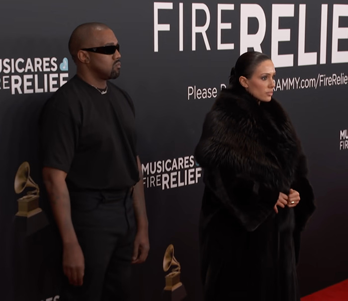 Kanye West in sunglasses and Bianca Censori in fur at the Grammys red carpet.