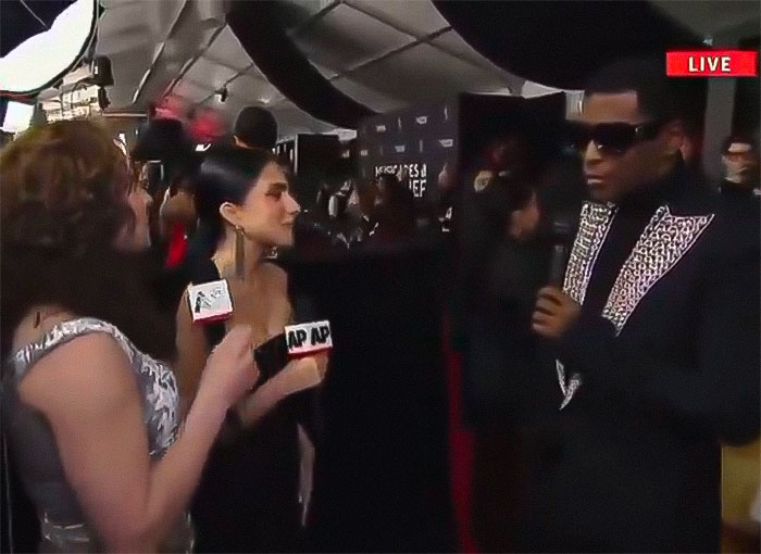 Reporters interviewing a celebrity at Grammys, live event coverage, related to a controversy over "R&B legend" snub.