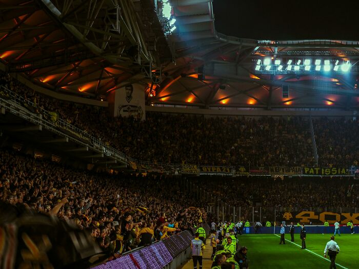 Crowd in a stadium during Bayern vs Celtic Champions League match, with fans cheering and vibrant atmosphere under stadium lights.