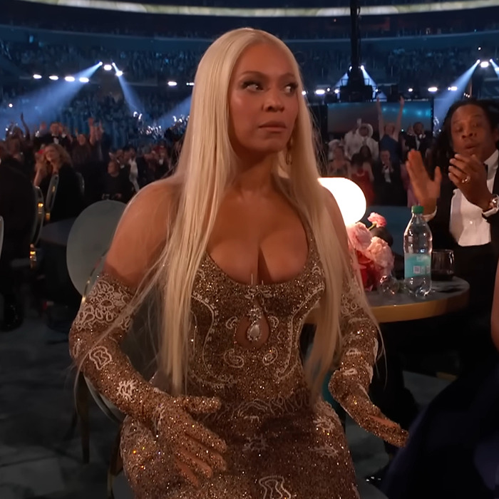 Blonde woman in a sparkling gown at an event with people applauding in the background, related to wardrobe malfunction story.