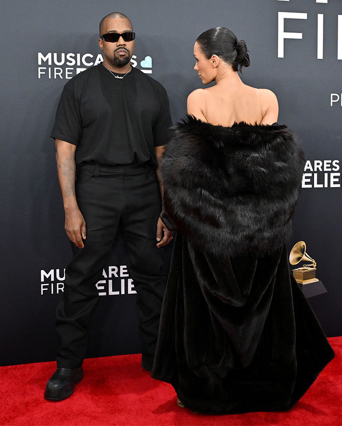 Bianca Censori in a second bare look at the Grammys afterparty, standing on the red carpet with another person.