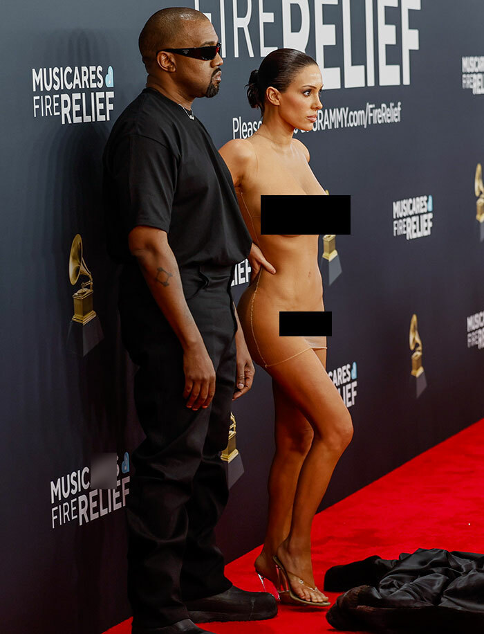 Man in black outfit and woman in minimal attire on red carpet, Bianca Censori second bare look afterparty event.