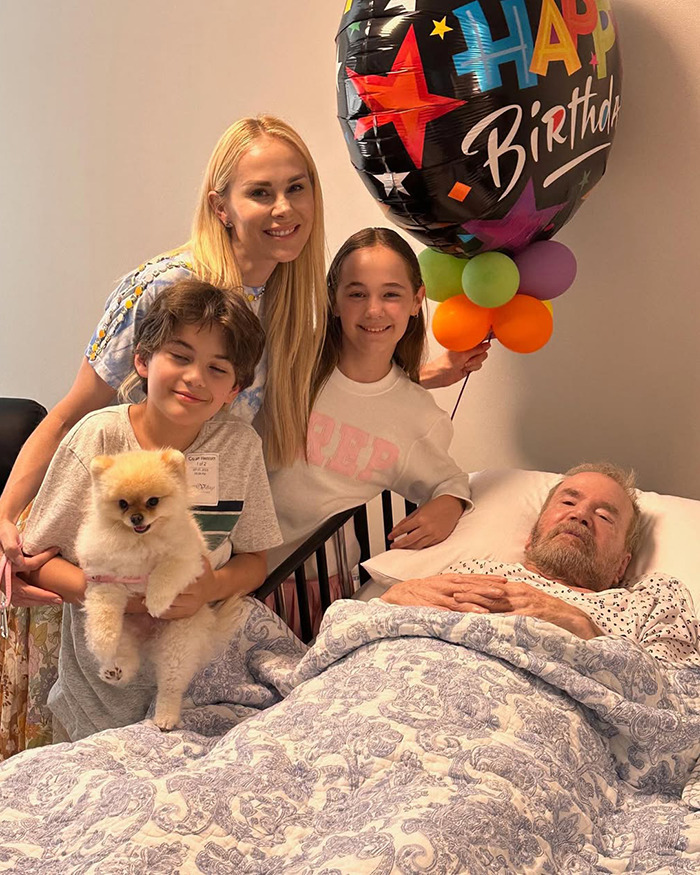 Family members with a birthday balloon and a dog visit a veteran in bed, expressing discontent with Katy Perry.