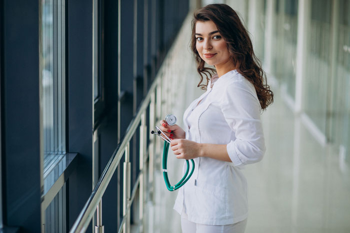 A woman in medical scrubs holding a stethoscope, representing professions with higher cheating rates.