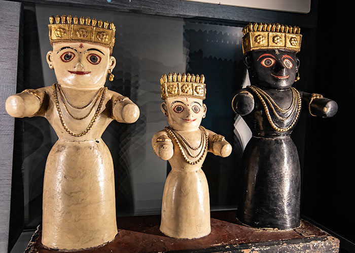 Three ancient statues displayed in a museum, showcasing cultural artifacts.