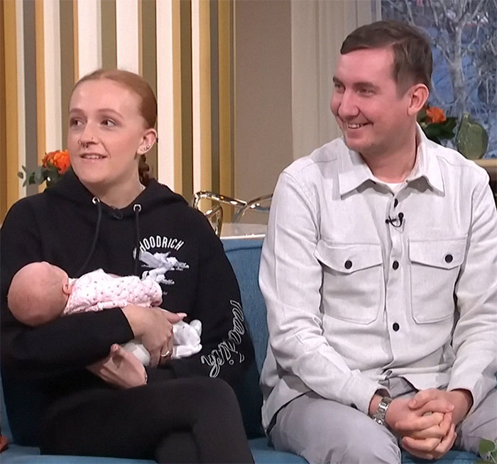 A woman with a baby and a man sitting on a couch, discussing a 1988 pregnancy case and its medical explanation.