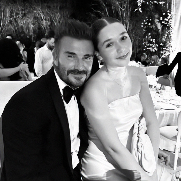 Father and daughter dressed elegantly at a formal event, sitting together and smiling warmly.