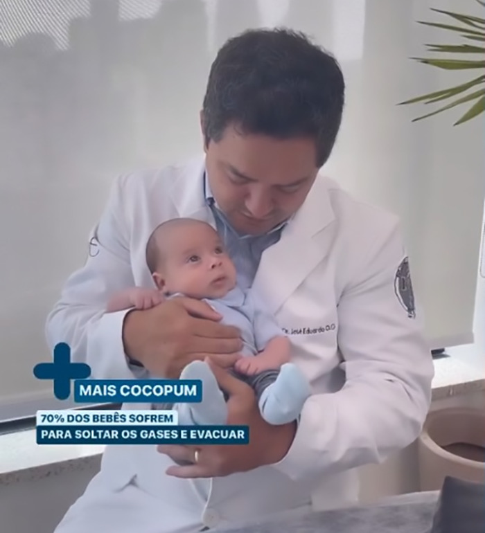 Doctor demonstrating viral baby farting tips with an infant in his arms, sparking online reactions.