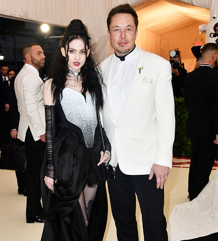 A couple in formal attire, posing at an event, related to Grimes and Elon Musk news.