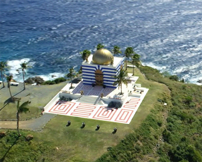 Aerial view of Jeffrey Epstein's island with a striped building by the ocean.