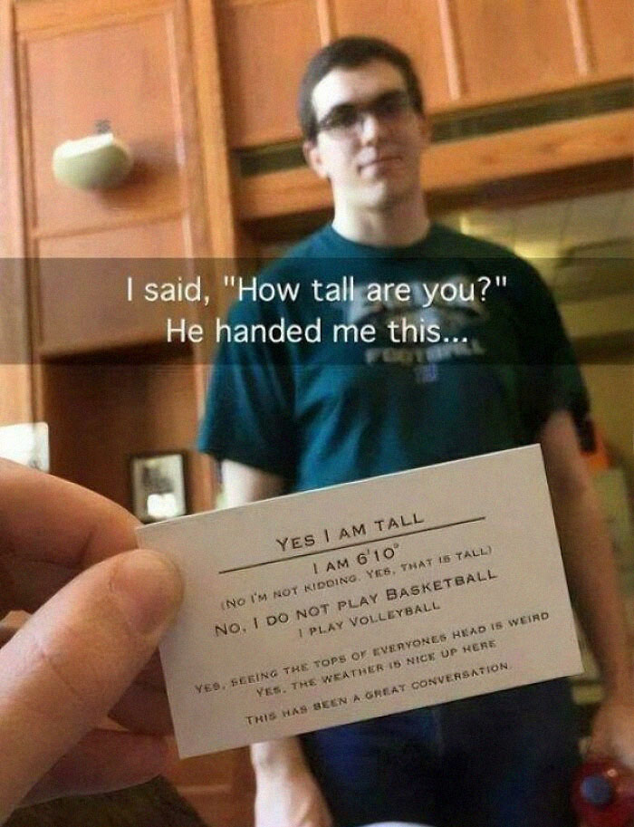 Tall person humorously presents card with height details, labeled "Yes I Am Tall", embodying a real-life "final boss".