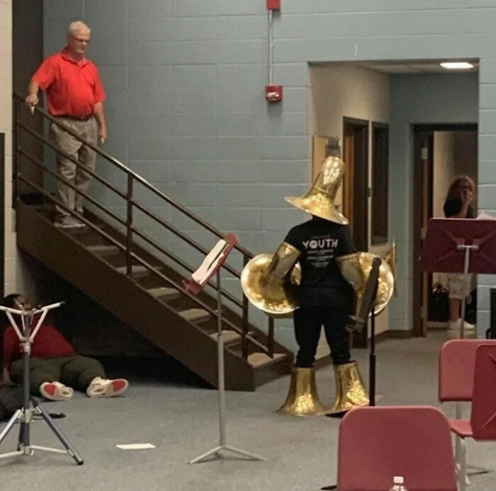 Person dressed in brass instruments resembling a "final boss" character in a music room.