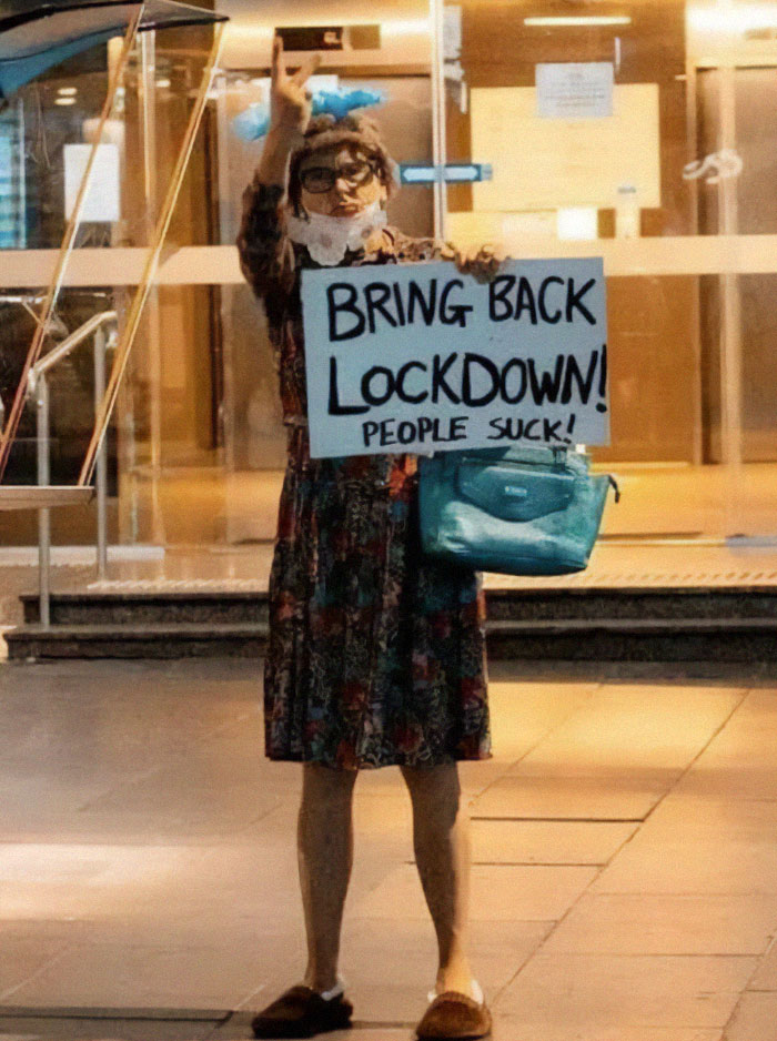 Person holding a "Bring Back Lockdown" sign, embodying a whimsical real-life final boss moment.