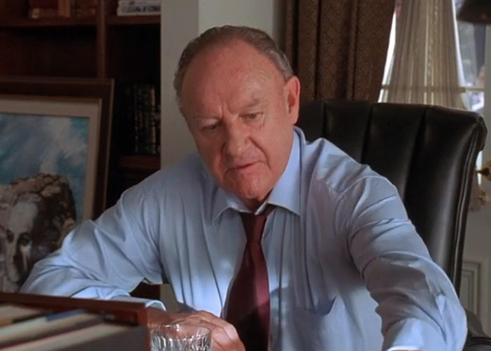 Gene Hackman wearing formal outfit in a movie scene.