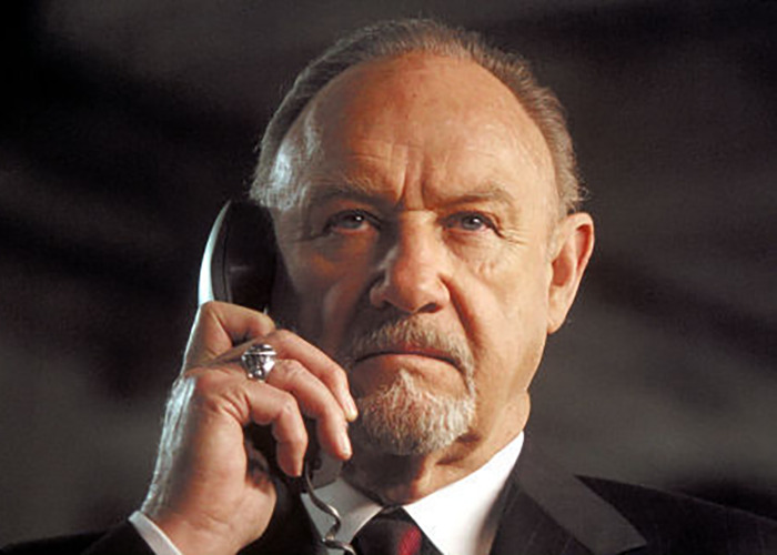 Gene Hackman holding a phone in a movie scene.