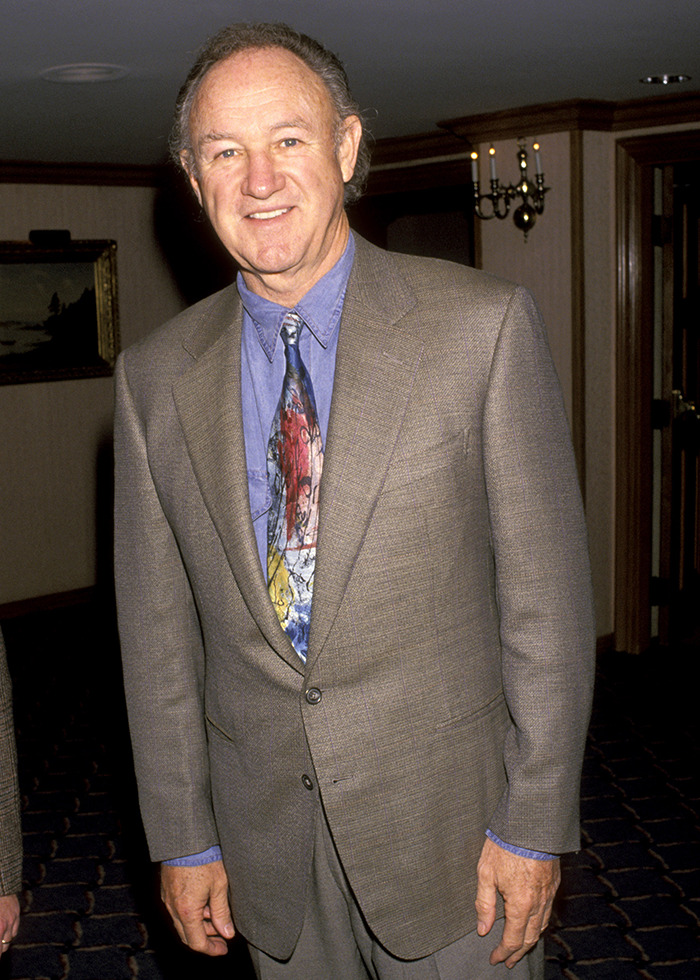 Gene Hackman wearing a formal suit indoors.