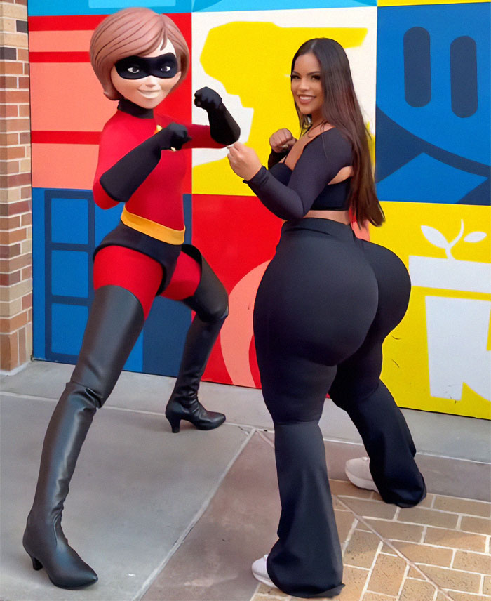 Woman posing with an Incredible character at Disneyland, colorful wall backdrop.