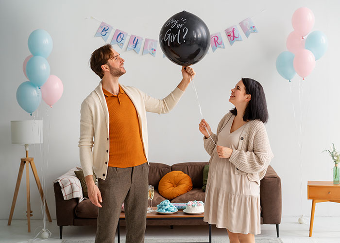 Man with sister holding a balloon at a baby shower, with pastel balloons and banners, highlighting family dynamics.