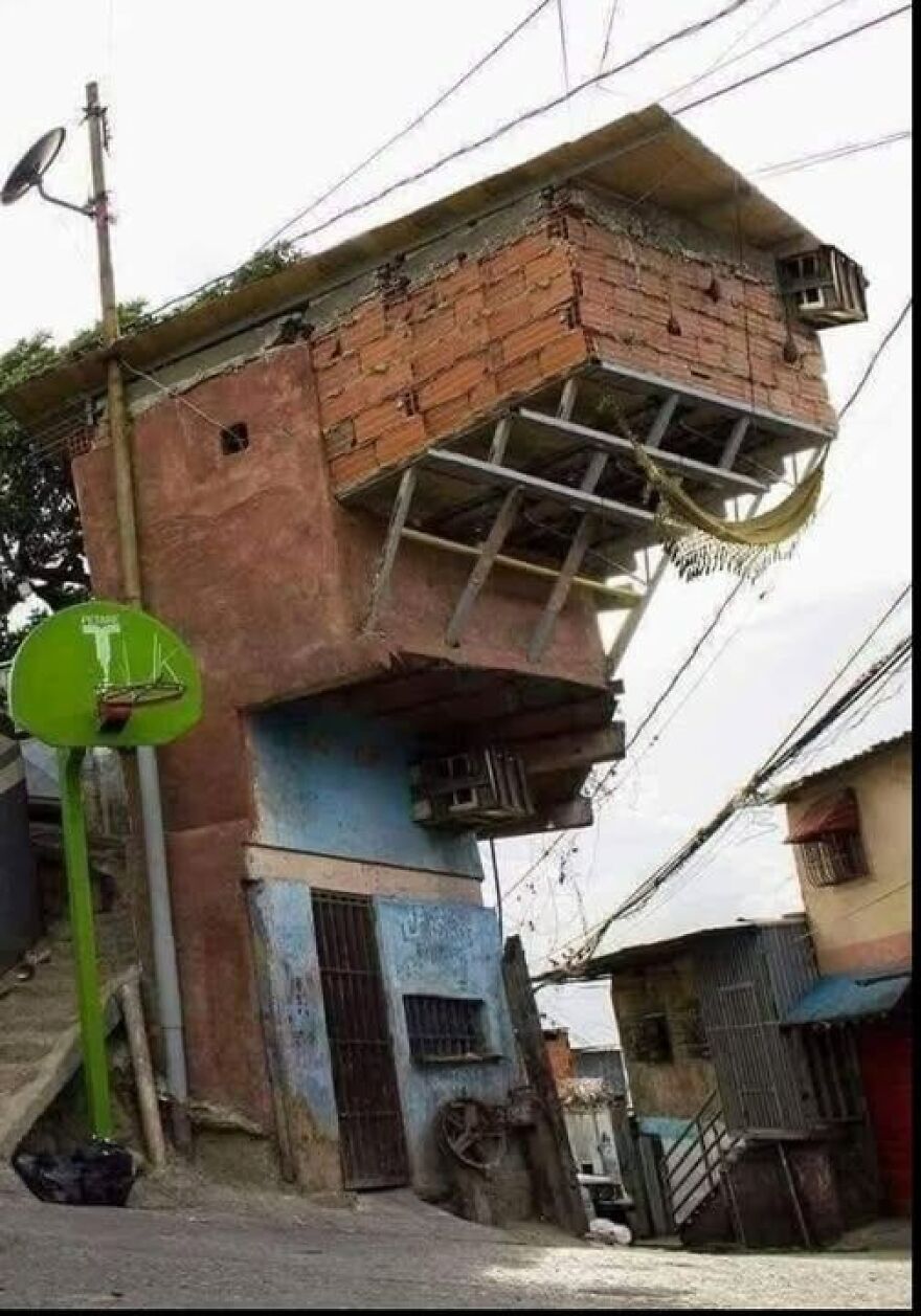 Unusual architecture with a top-heavy, precarious brick structure on a narrow building base.